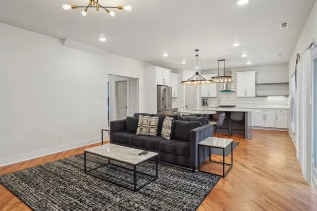 a living room with kitchen island furniture and a dining table with wooden floor