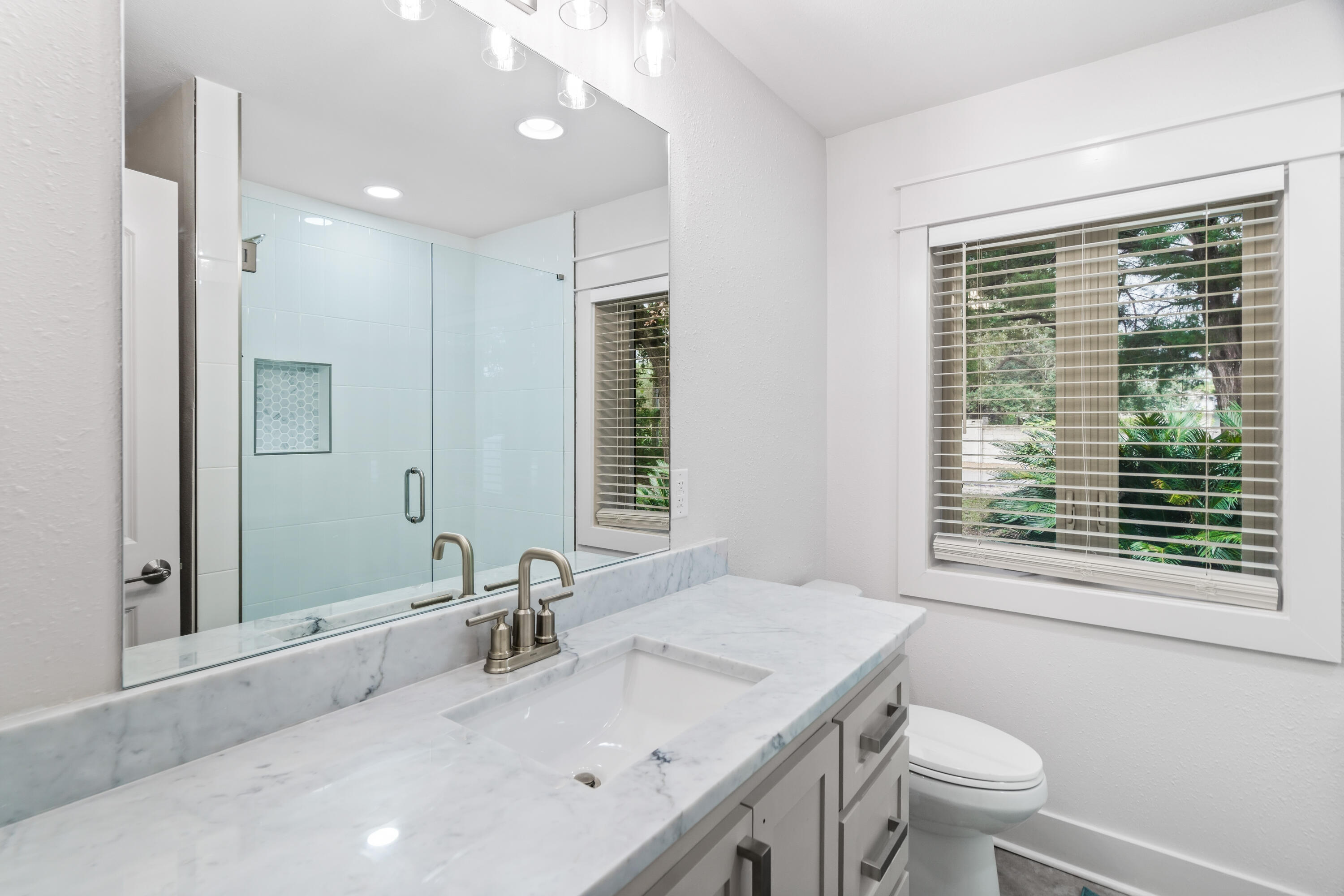 200 Beach Drive West Miramar Beach, FL 32550 - Photo 35 of 45 a bathroom with a granite countertop sink toilet a large mirror and a window