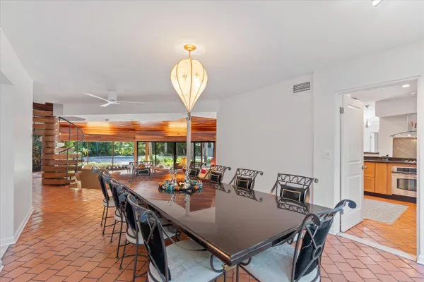 a dining room with furniture a large window and a chandelier