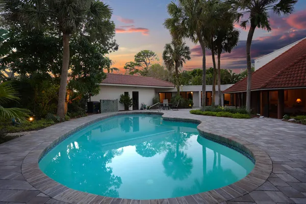 a view of a house with pool and sitting area