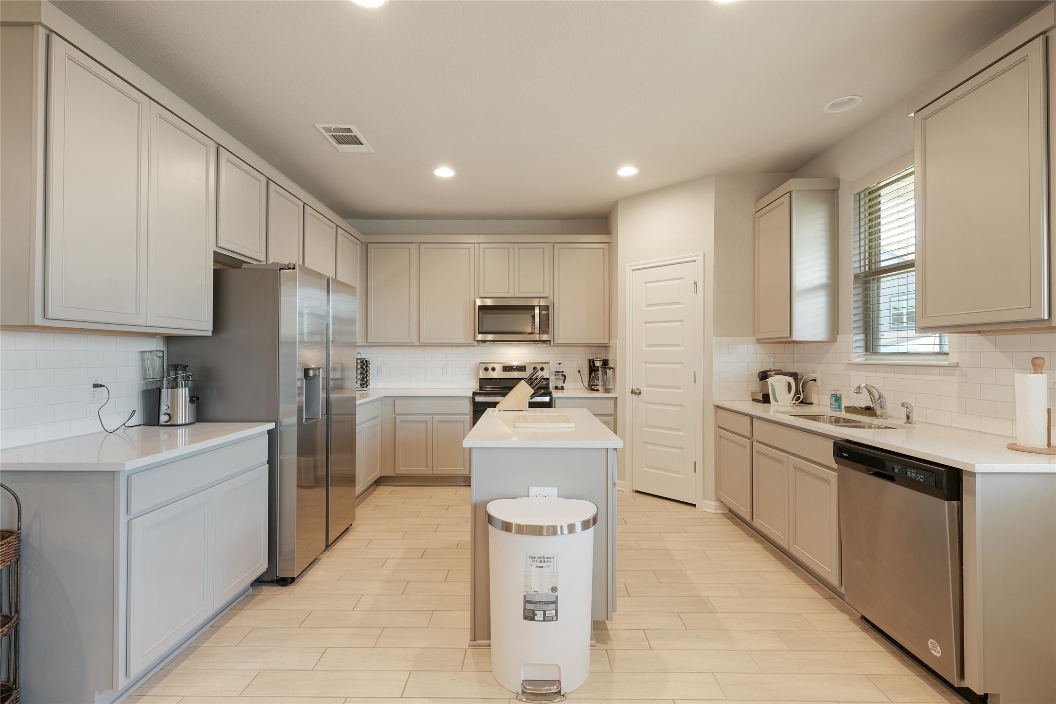 108 Drifter Lane Jarrell, TX 76537 - Photo 1 of 12 Kitchen with tasteful backsplash, stainless steel appliances, a center island, recessed lighting, and light stone counters