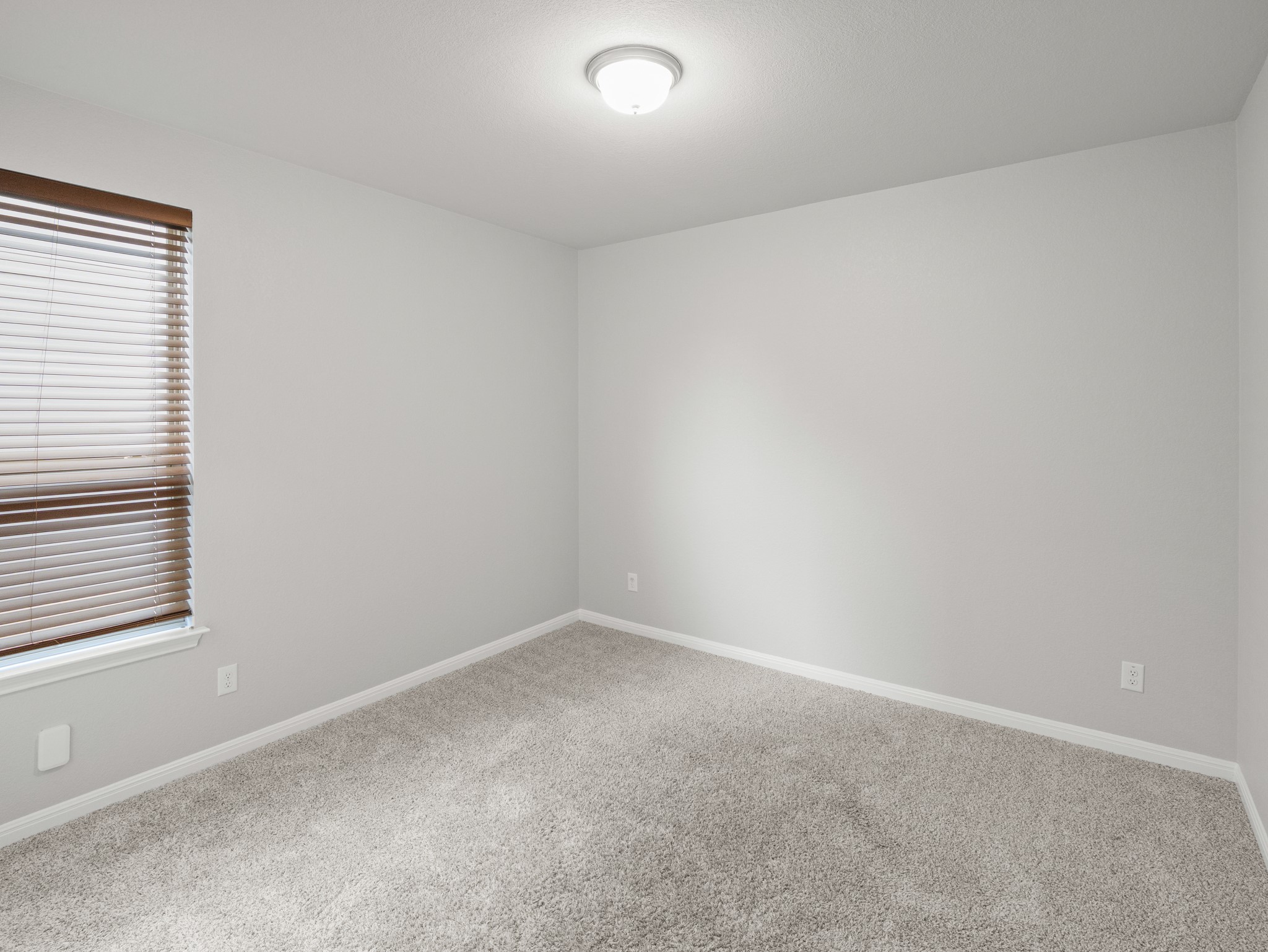108 Drifter Lane Jarrell, TX 76537 - Photo 4 of 6 Neutral-toned room featuring a single window with horizontal blinds, light gray wall paint, and gray carpeting