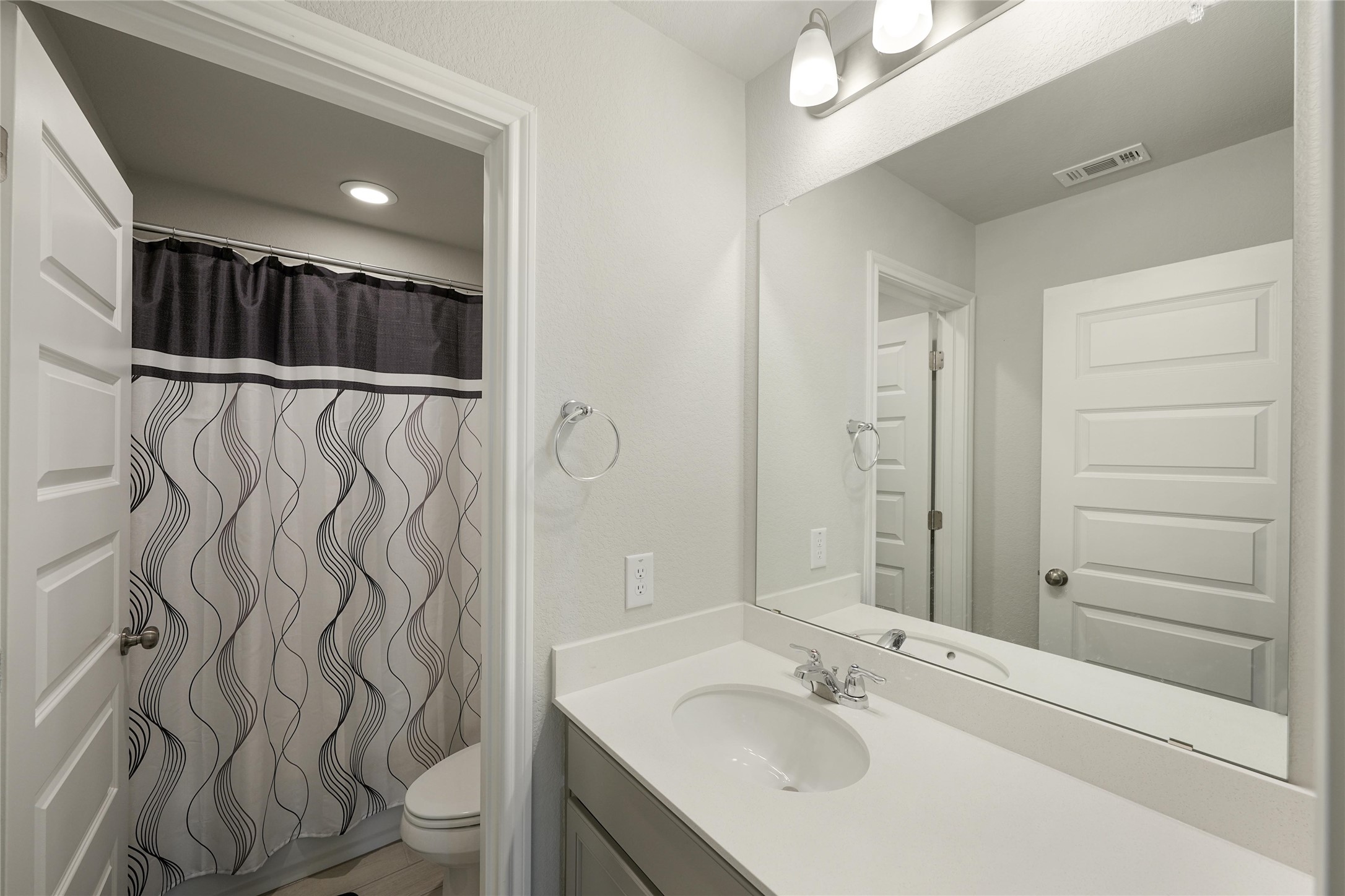 108 Drifter Lane Jarrell, TX 76537 - Photo 9 of 12 Bathroom with curtained shower, vanity, and recessed lighting
