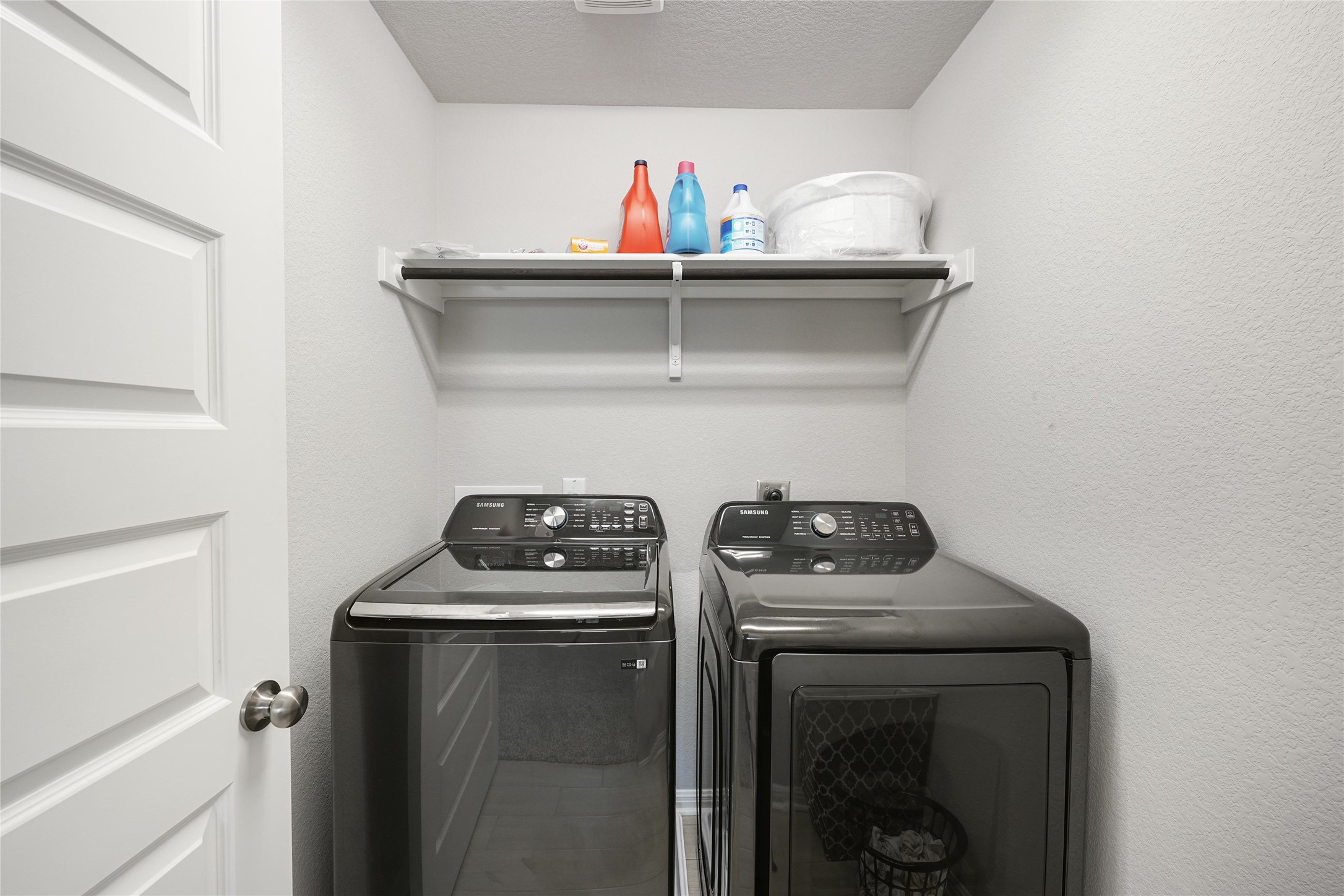 108 Drifter Lane Jarrell, TX 76537 - Photo 10 of 12 Laundry area with washing machine and clothes dryer, a textured ceiling, and a textured wall