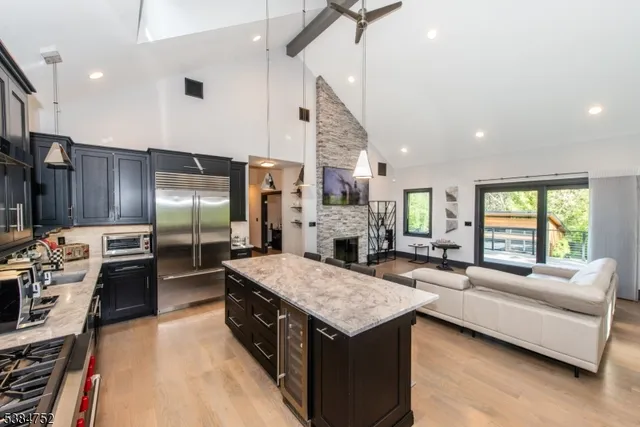 a large kitchen with granite countertop a large counter top appliances and cabinets