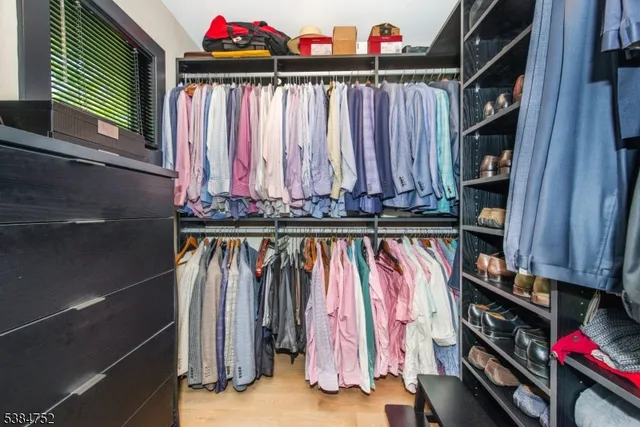 a view of walk in closet with clothes and shoes