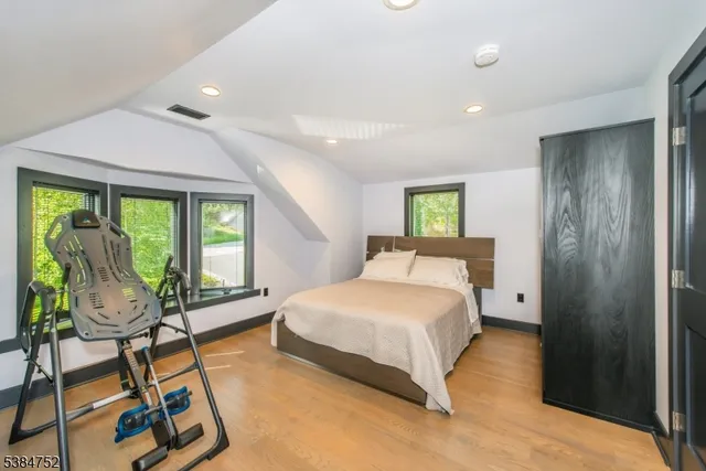 a spacious bedroom with a bed a window and chair