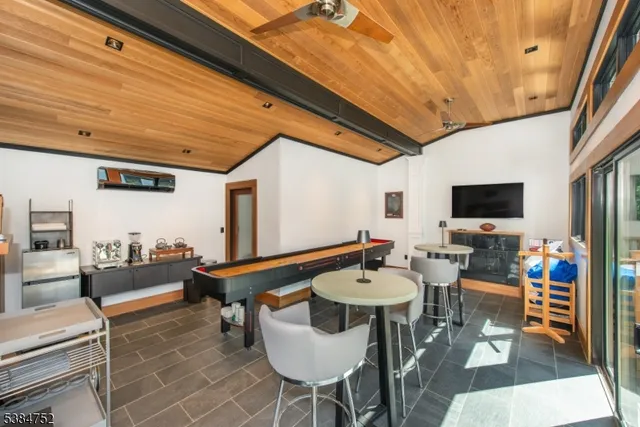 a outdoor dining space with furniture and a flat screen tv