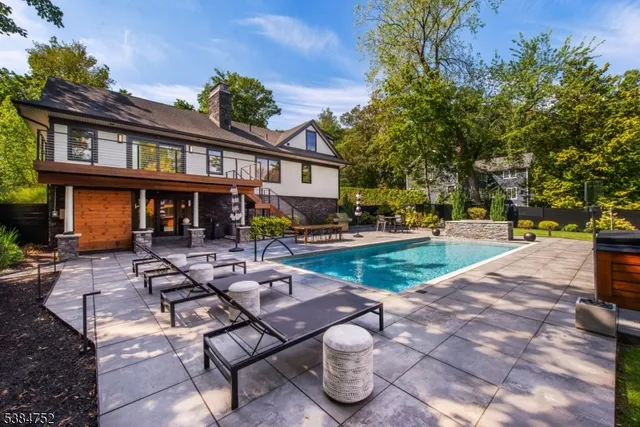 a view of a patio with couches table and chairs with plants and trees