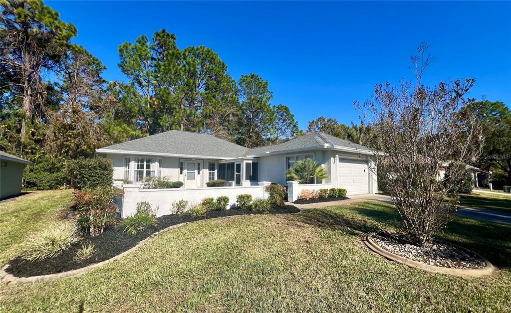 7205 Southwest 115th Place Ocala, FL 34476 - Photo 24 of 24 a front view of a house with a yard and trees