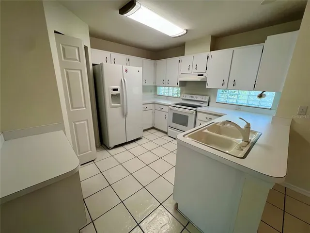 a kitchen with a refrigerator sink stove and cabinets
