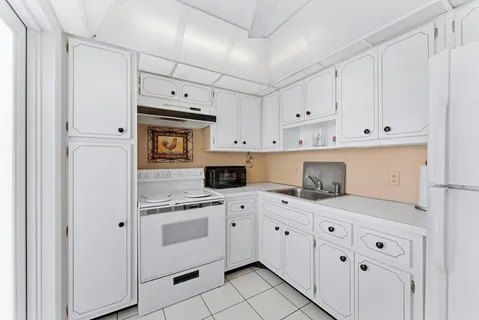 a kitchen with white cabinets and white appliances