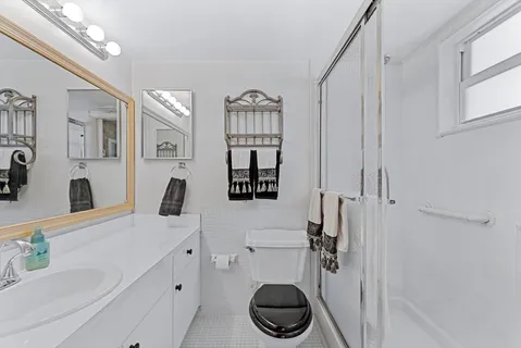 a bathroom with a toilet sink and mirror