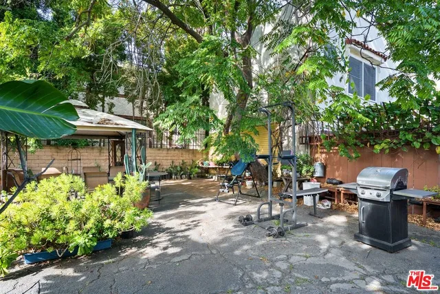 a view of a patio with table and chairs under an umbrella