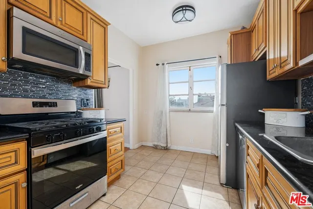 a kitchen with stainless steel appliances granite countertop a refrigerator sink and stove
