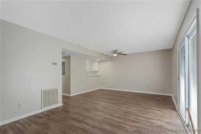 a view of an empty room with wooden floor