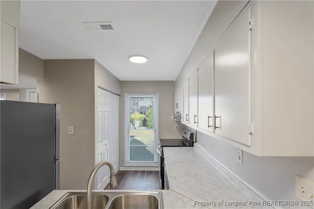 a kitchen with white cabinets and appliances