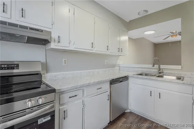 a kitchen with a sink a refrigerator and cabinets