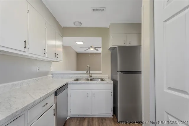 a kitchen with a refrigerator sink and cabinets