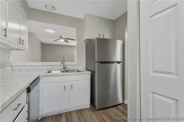 a kitchen with stainless steel appliances granite countertop white cabinets and a counter top space