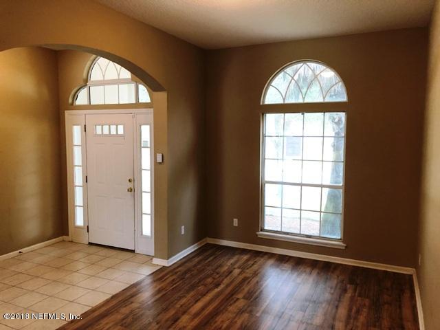 12067 Spring Ridge Drive Jacksonville, FL 32258 - Photo 4 of 36 an empty room with wooden floor and a window
