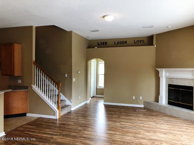 12067 Spring Ridge Drive Jacksonville, FL 32258 - Photo 8 of 36 a view of an empty room with wooden floor and a fireplace