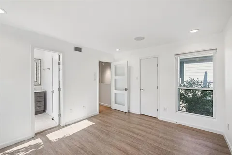 a view of a livingroom with wooden floor and a bathroom