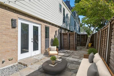 a view of a patio with couches table and chairs and potted plants