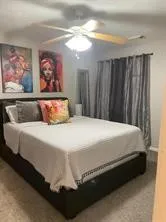 a bedroom with a bed and painting on the wall