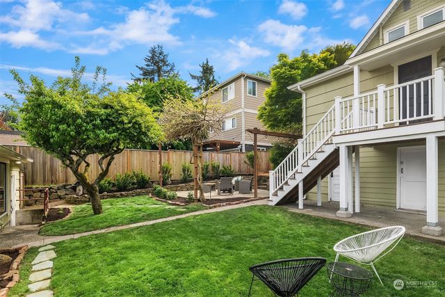 a view of a house with backyard and sitting area