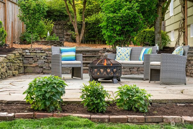 a view of a patio with table and chairs potted plants and a large tree