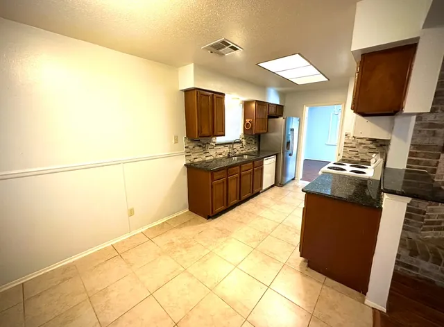 a kitchen with stainless steel appliances granite countertop a sink and cabinets