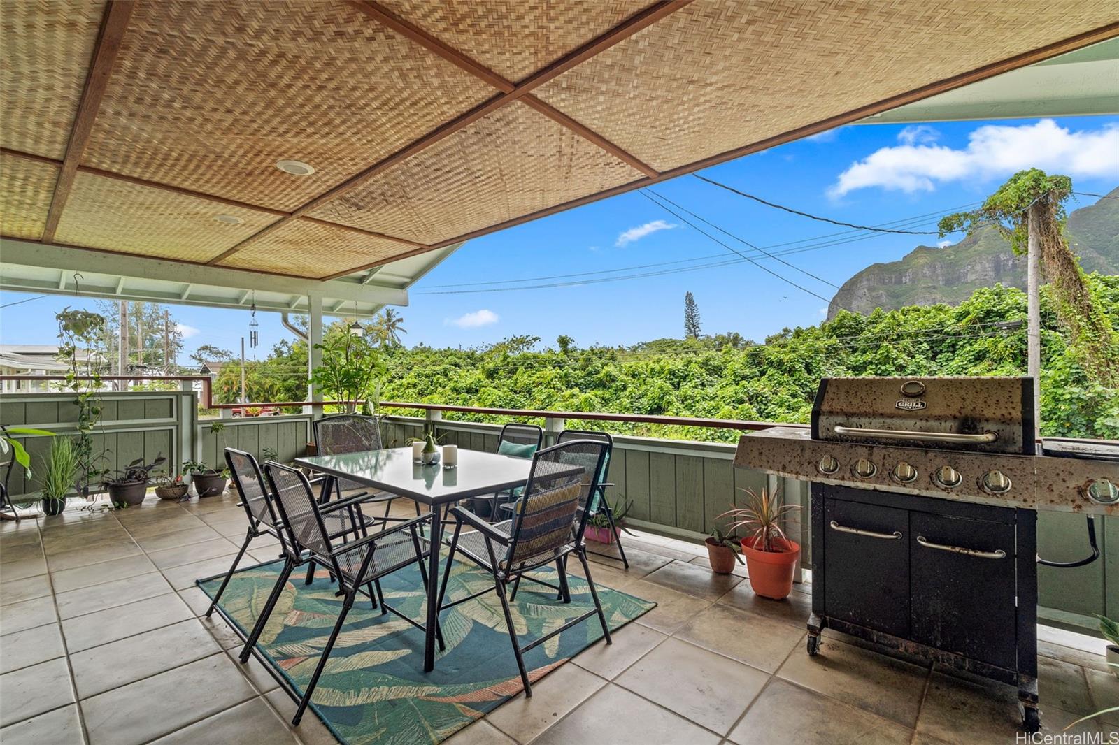 51-17 Kaʻaʻawa Place Kaaawa, HI 96730 - Photo 4 of 25 a patio with a table and chairs under an umbrella