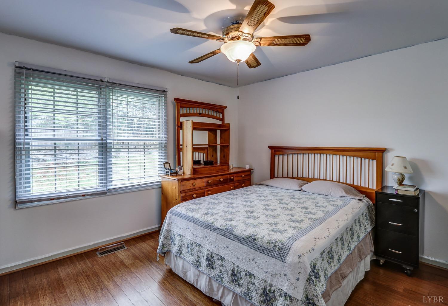 127 Southern Lane Monroe, VA 24574 - Photo 20 of 44 a bedroom with a large bed chandelier and a window