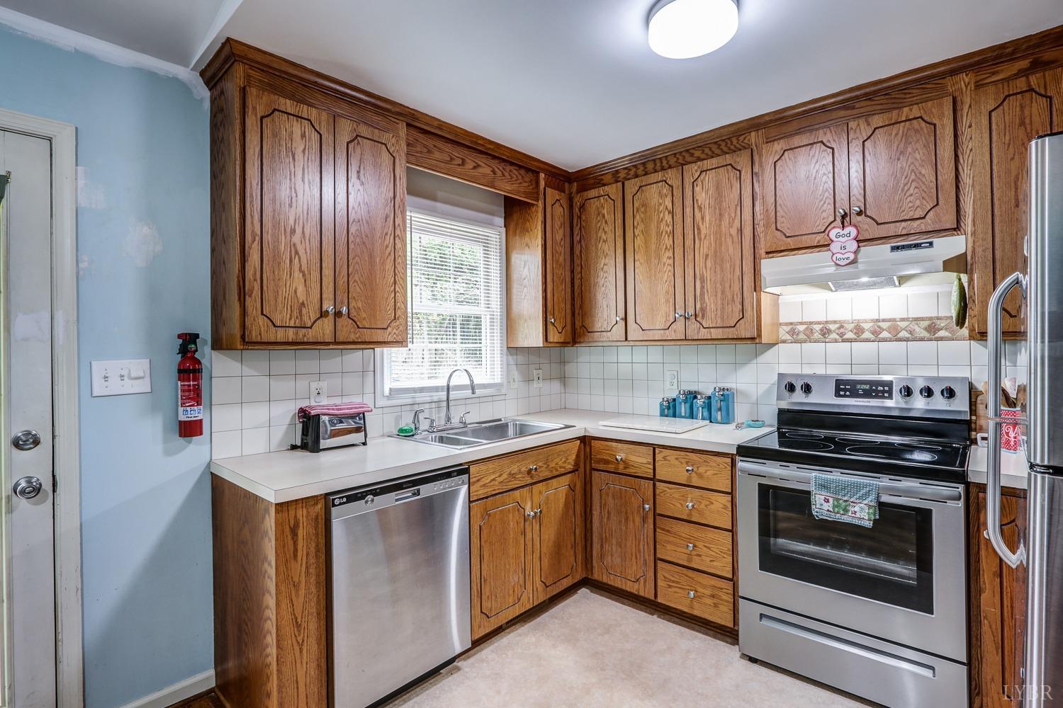 127 Southern Lane Monroe, VA 24574 - Photo 4 of 44 a kitchen with stainless steel appliances granite countertop a stove a sink and dishwasher a refrigerator with wooden cabinets