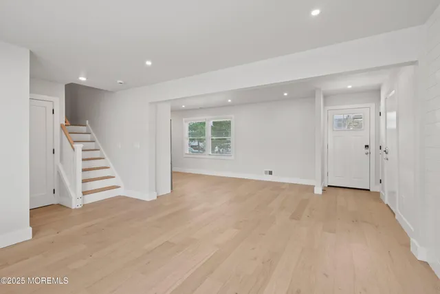 an empty room with wooden floor and white walls