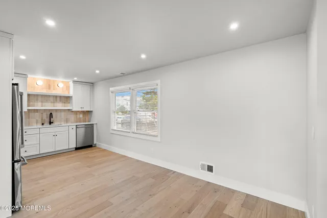 a large space with a large window and kitchen view