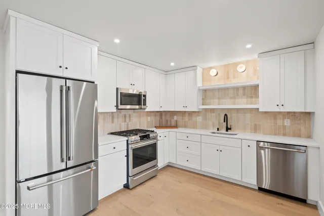 a kitchen with cabinets stainless steel appliances and sink