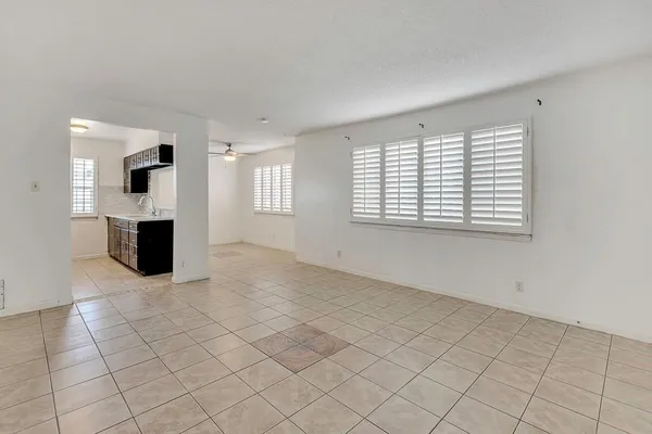 an empty room with windows and fireplace