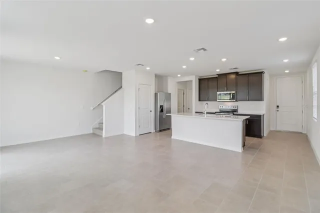 a view of kitchen with kitchen island a sink stainless steel appliances and cabinets