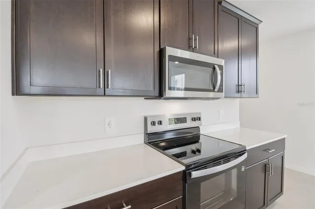 a kitchen with granite countertop white cabinets and stainless steel appliances