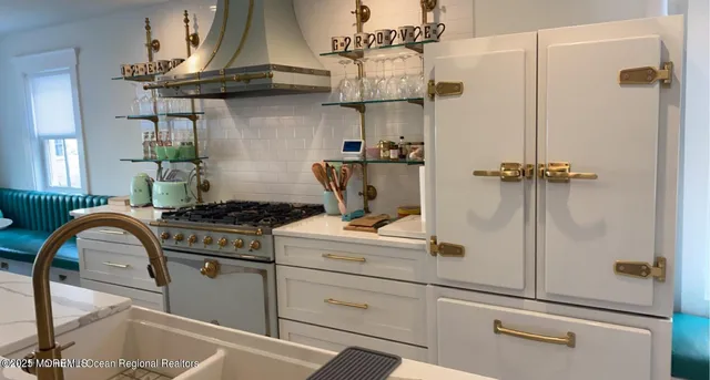 a kitchen with stainless steel appliances kitchen island granite countertop a stove a sink a dining table and chairs with wooden floor