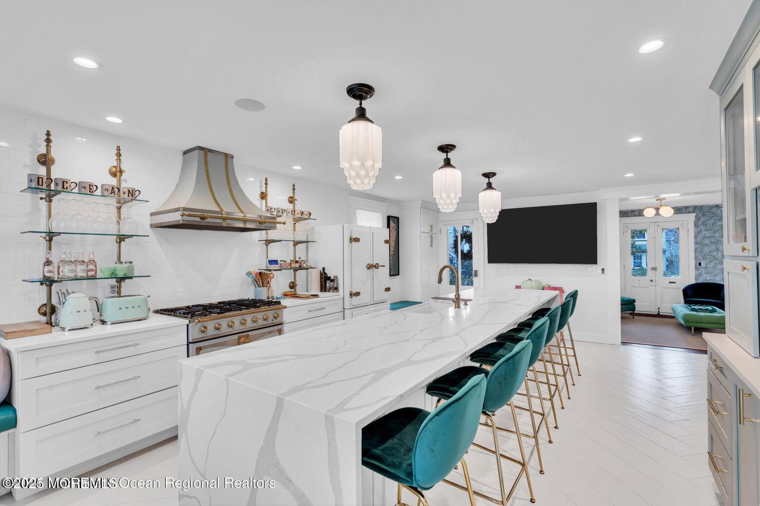 69 Webb Avenue Ocean Grove, NJ 07756 - Photo 31 of 70 a kitchen with stainless steel appliances kitchen island granite countertop a stove a sink a dining table and chairs with wooden floor