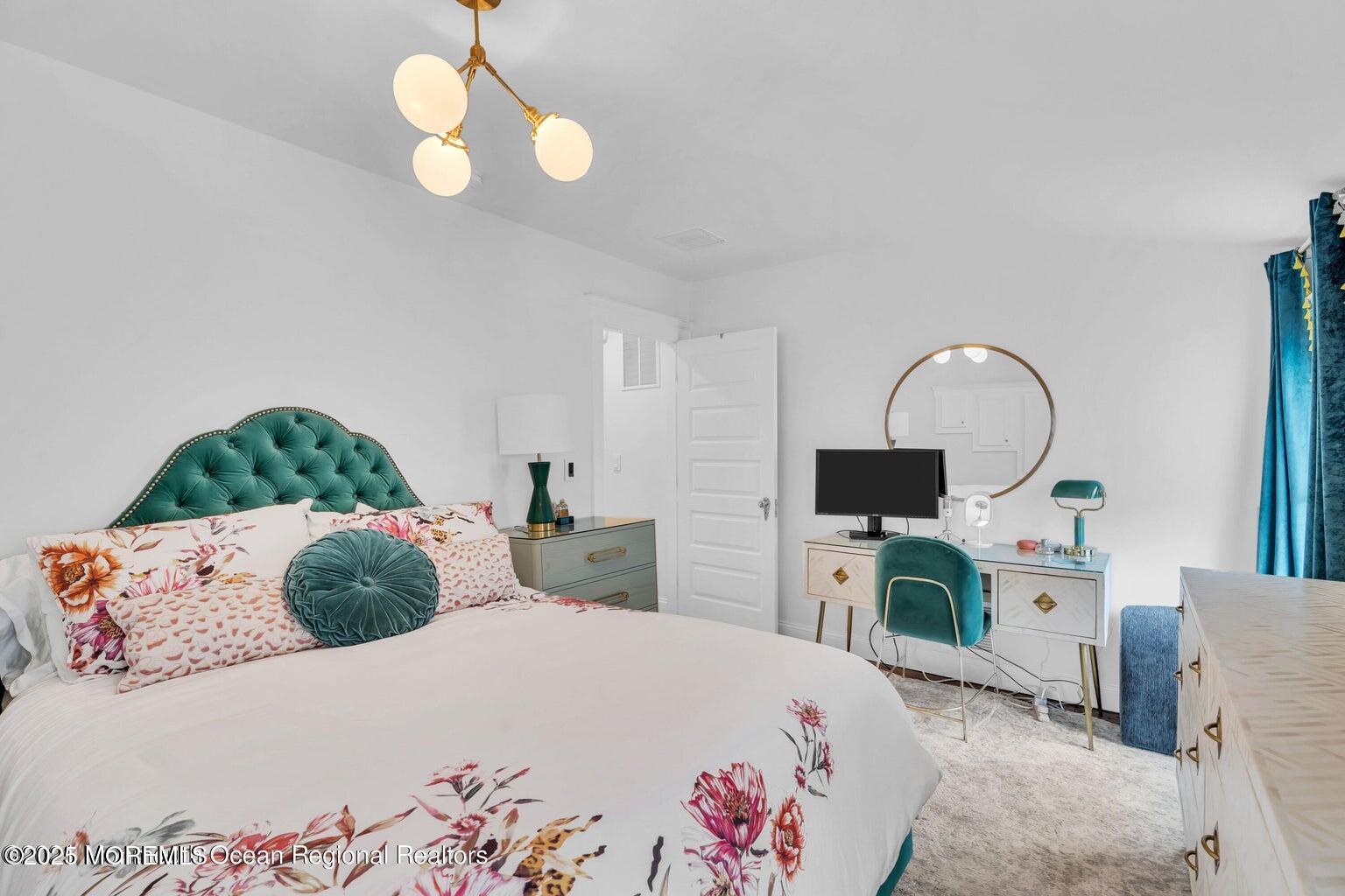 69 Webb Avenue Ocean Grove, NJ 07756 - Photo 53 of 70 a bedroom with a bed potted plant on dresser and a chandelier