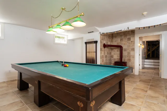 a room with pool table and windows