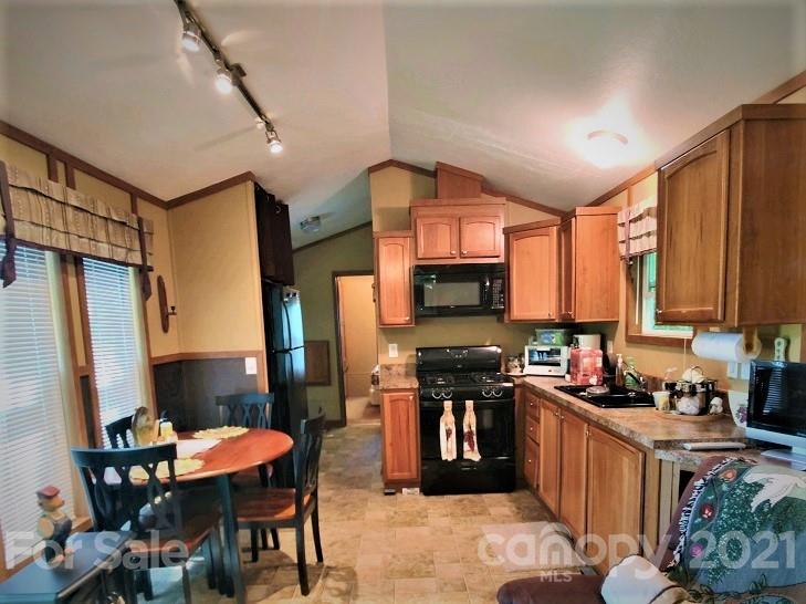 83 Choke Berry Ridge, Unit 1 Sylva, NC 28779 - Photo 3 of 13 a kitchen with stainless steel appliances granite countertop sink stove top oven table and chairs