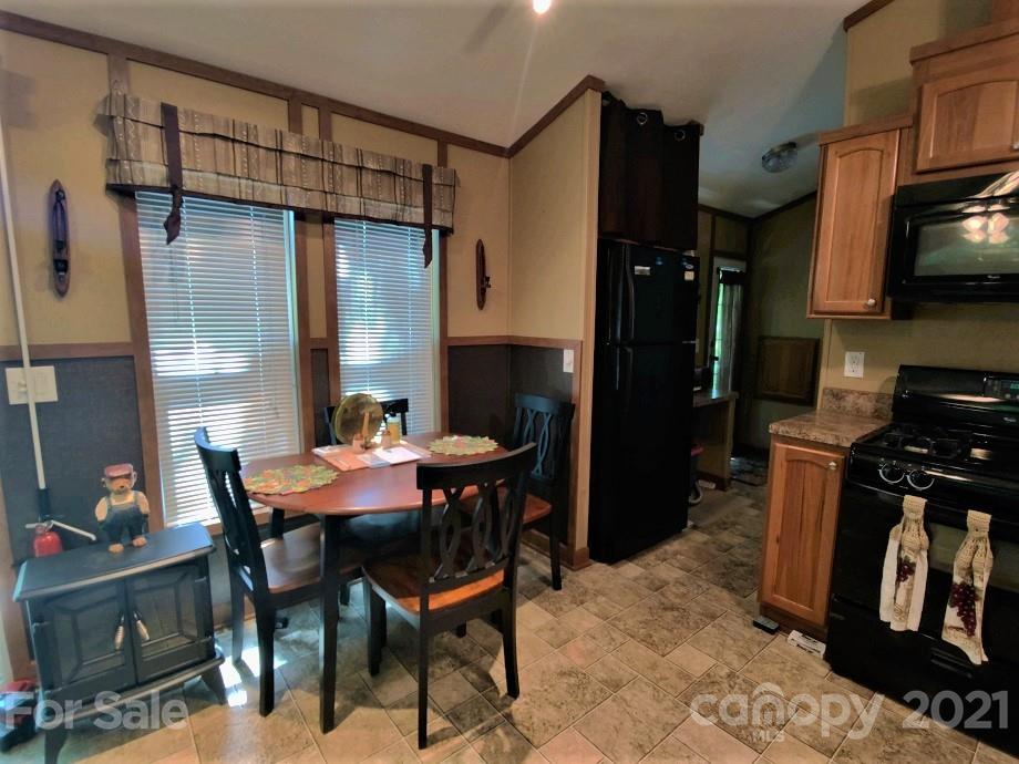 83 Choke Berry Ridge, Unit 1 Sylva, NC 28779 - Photo 4 of 13 a kitchen with a table chairs and a refrigerator