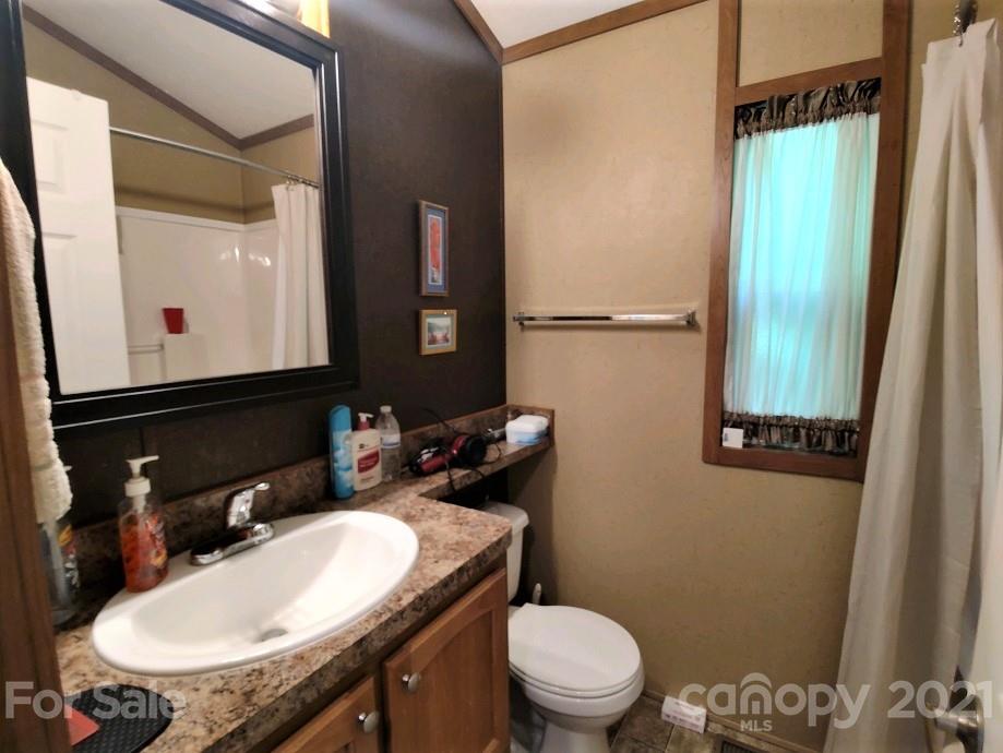 83 Choke Berry Ridge, Unit 1 Sylva, NC 28779 - Photo 8 of 13 a bathroom with a granite countertop sink toilet and mirror