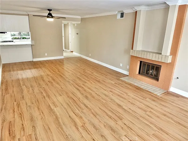 a view of a hallway with wooden floor and a fireplace