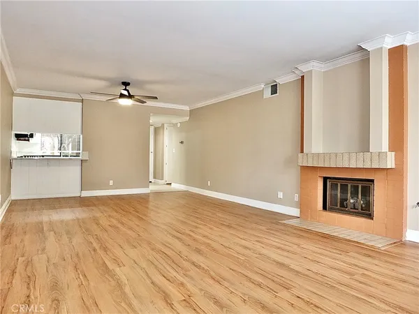 a view of empty room with wooden floor and fireplace